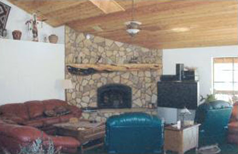 Timberlake living room with river rock fireplace and knotty pine ceiling